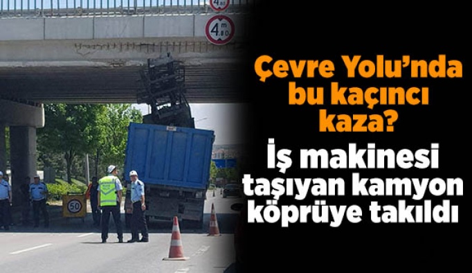 İş makinesi taşıyan kamyon köprüye takıldı